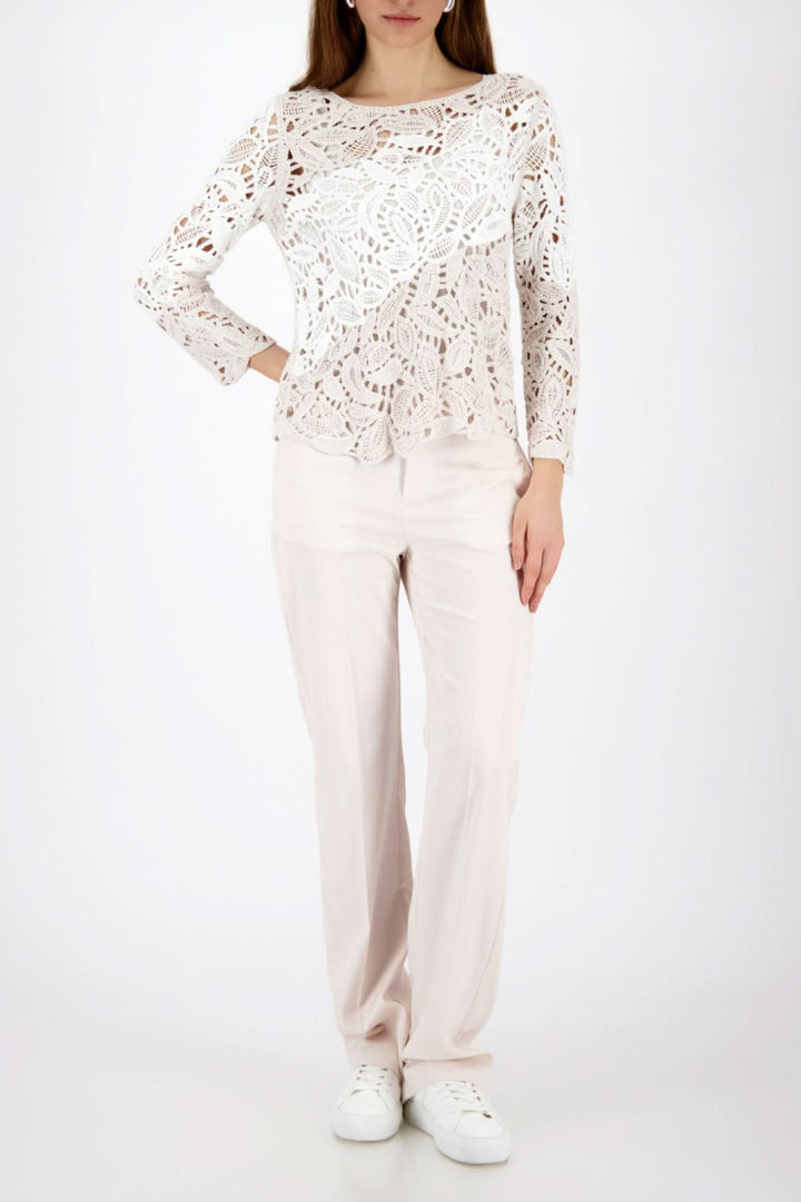 Femme portant un chandail ajouré à motif géométrique avec tricot raffiné et style moderne, idéal pour superposer avec élégance.