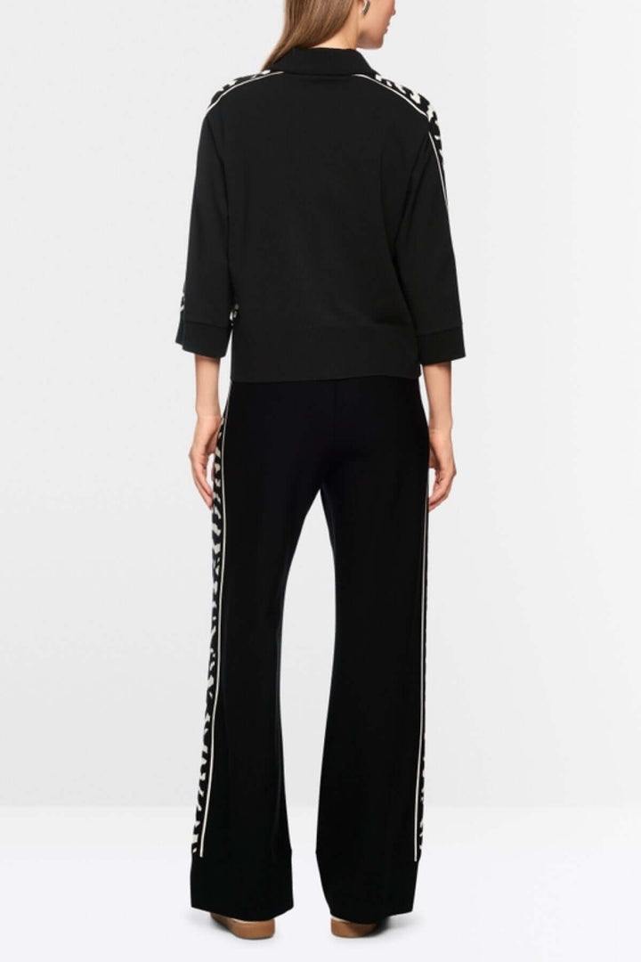 Chandail ample noir avec manches 3/4 et détails motif animalier, vue de dos, porté par une personne, label « Rethink Together ».