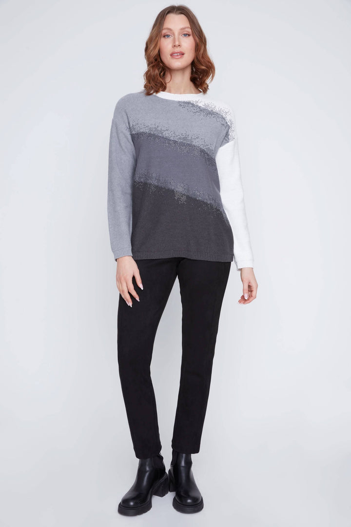 Femme portant un chandail avec dégradés en maille douce avec manches longues et détails scintillants, style chic et décontracté.