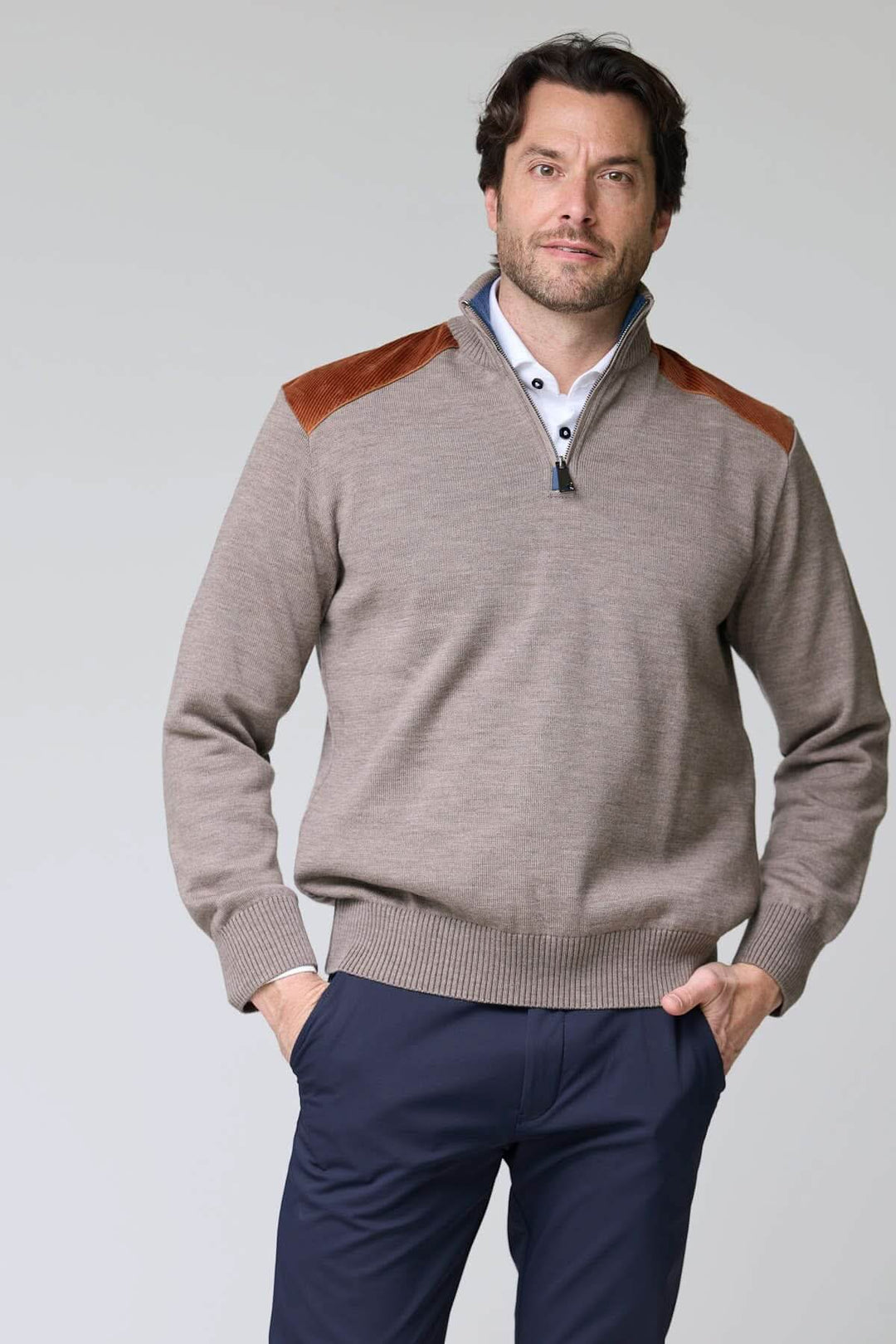 Homme portant un chandail à col demi-glissière avec empiècements contrastants, style décontracté chic.