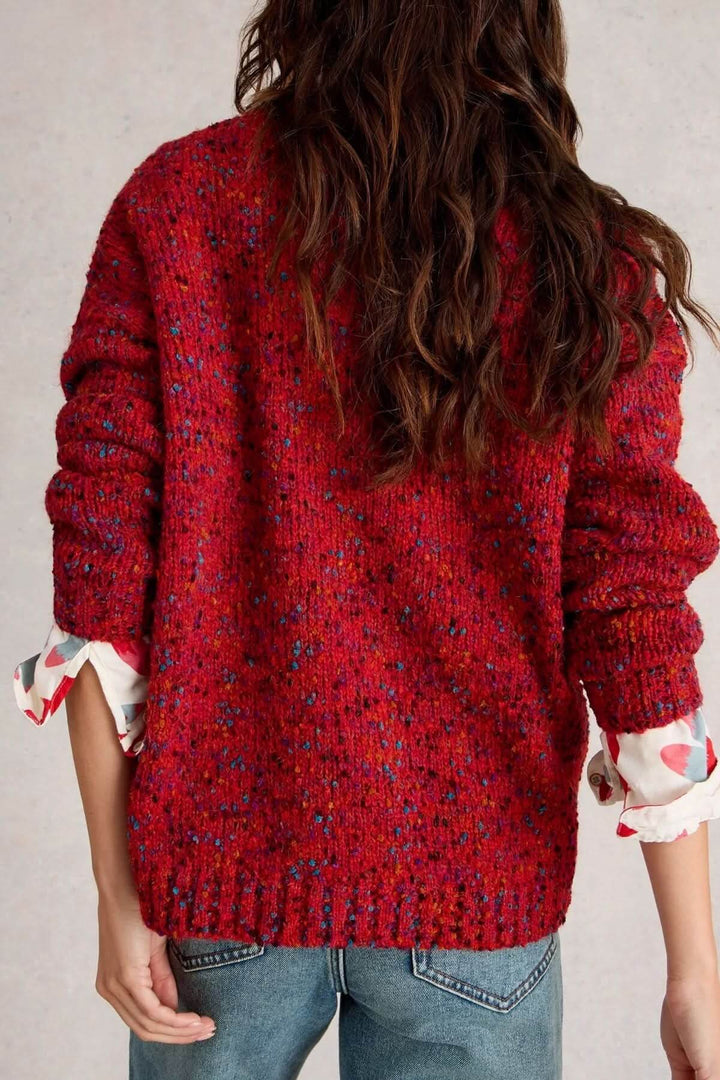 Chandail col en V en maille rouge chinée, coupe décontractée, porté sur une chemise à motifs.