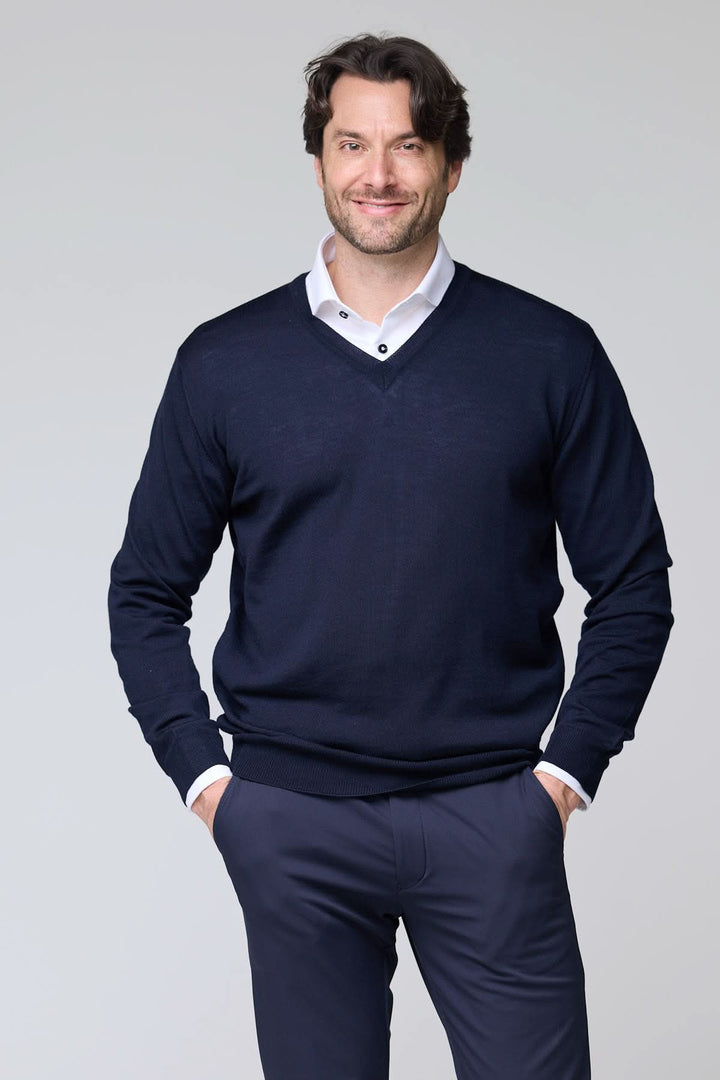 Homme portant un Chandail col en V en laine mérinos bleu marine, élégant et respirant, sur une chemise blanche.