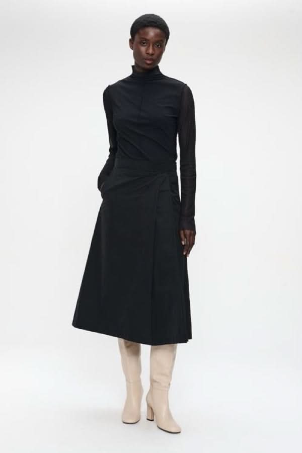 Chandail à col montant et manches transparentes en noir, idéal pour des tenues élégantes avec détails de style moderne et sophistiqué.