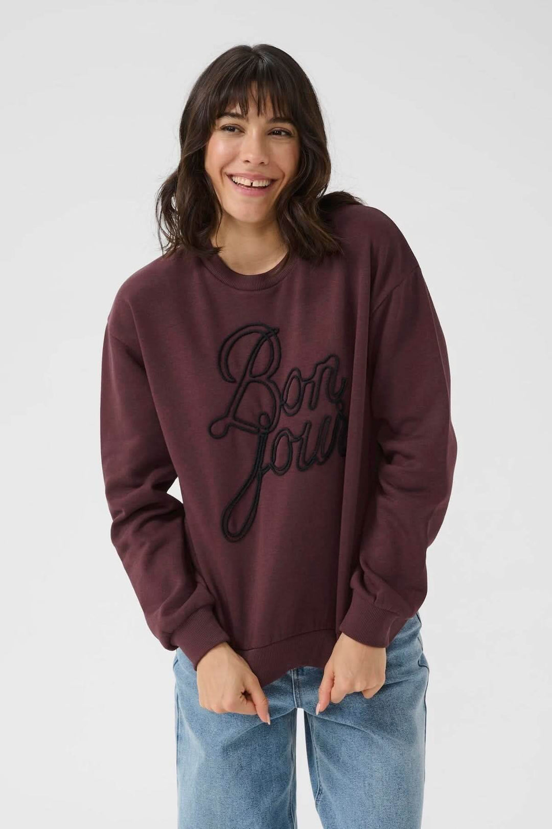 Chandail à col rond bordeaux avec inscription brodée 'Bonjour', style universitaire et décontracté.