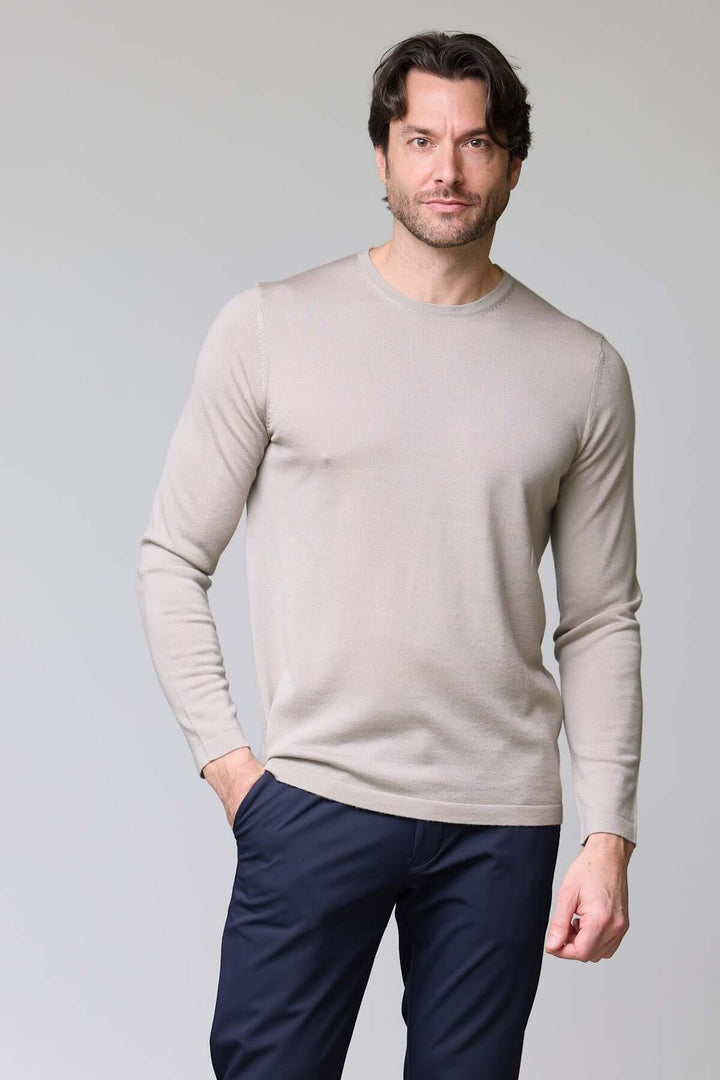 Homme portant un chandail col rond en tricot fin, texture douce et fluide, allure élégante, idéal seul ou sous un veston, couleur neutre.