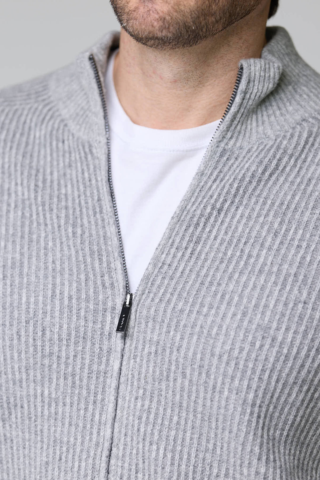 Homme portant un chandail à demi-glissière torsadé en laine mérinos gris, montrant le motif côtelé et la fermeture éclair élégante.