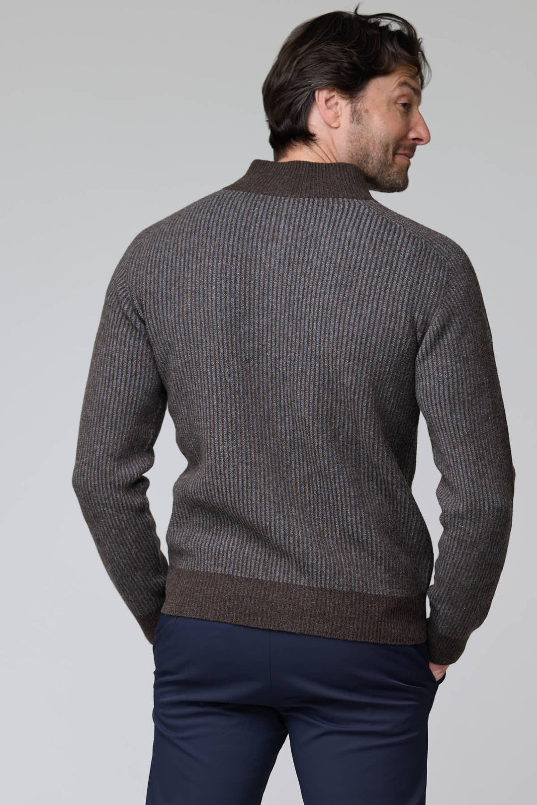 Homme portant un chandail à demi-glissière torsadé en laine mérinos, motif élégant, col montant, ourlets et poignets côtelés.