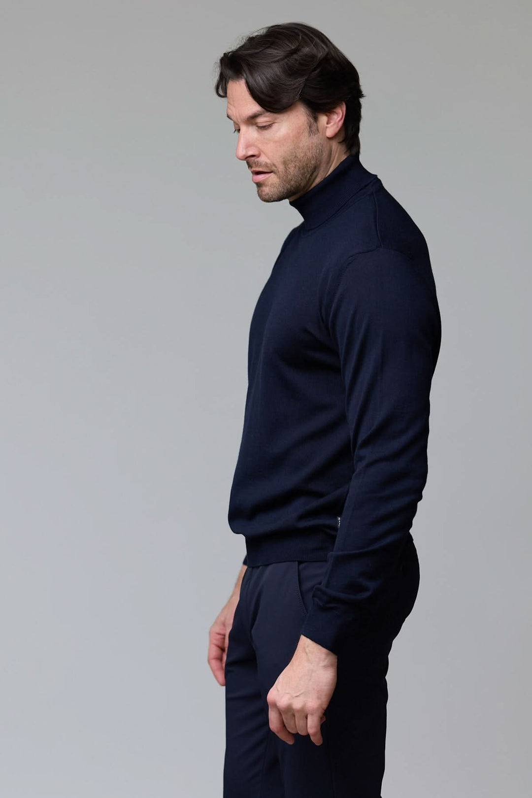 Homme portant un chandail en laine mérinos fine bleu marine, col rond, coupe droite, élégant et confortable.