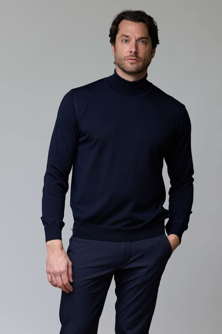 Homme portant un chandail en laine mérinos fine bleu foncé avec col rond et bordure côtelée pour un look élégant et intemporel.