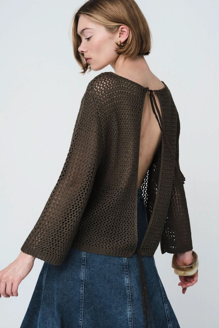 Chandail en maille ajourée de couleur sombre porté par une femme, mettant en valeur le design ouvert et élégant du dos.