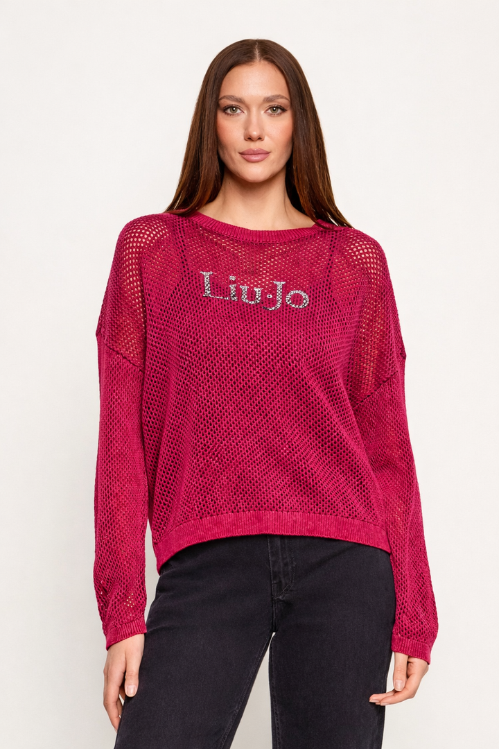 Femme portant un chandail en maille ajourée Liu Jo Sport rose avec logo Liu Jo, manches longues et coupe décontractée, idéale pour superpositions.