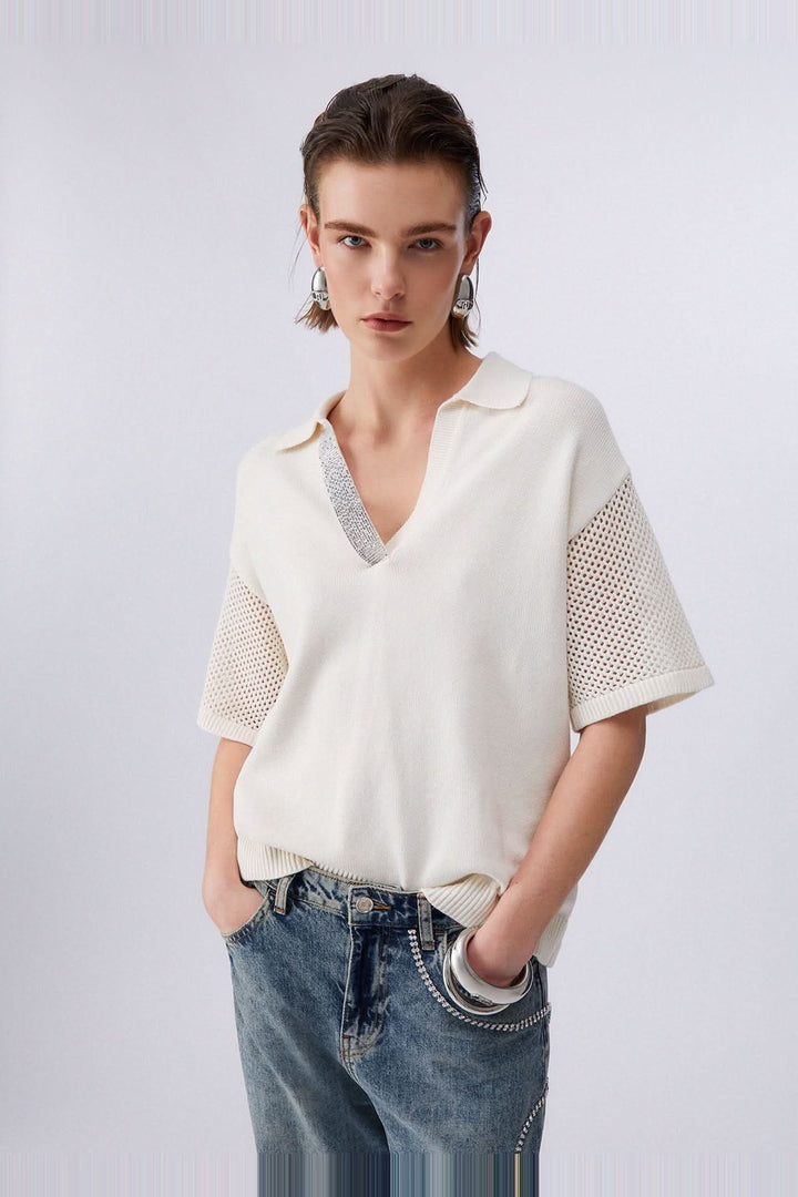 Femme portant un chandail en maille avec col polo et strass, manches courtes avec inserts ajourés, style moderne et élégant.