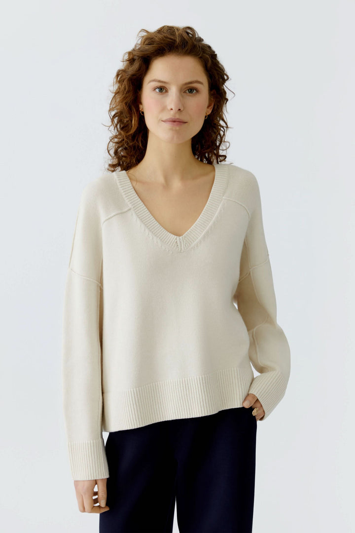 Chandail en maille à col en V en laine douce, manches longues et épaules tombantes, pour un style moderne et raffiné.