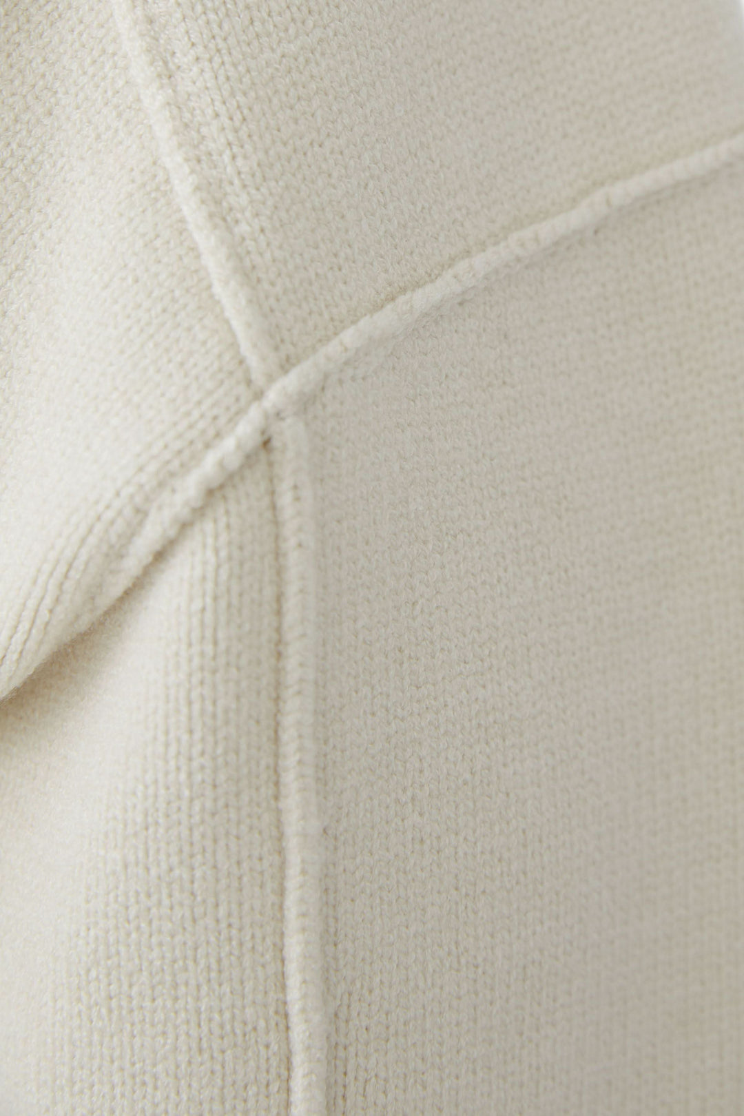 Texte rapproché sur la texture du Chandail en maille à col en V en tissu doux et épuré, montrant la couture détaillée.