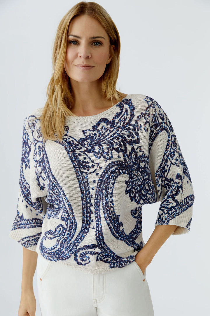 Femme portant un chandail en maille à motif cachemire avec manches trois-quarts, idéal pour un look fluide et moderne.