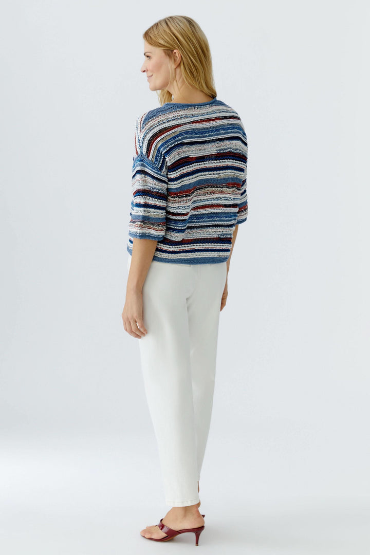 Chandail en maille multicolore à manches trois-quarts sur mannequin vu de dos, ajoutant modernité et relief au look décontracté-chic.