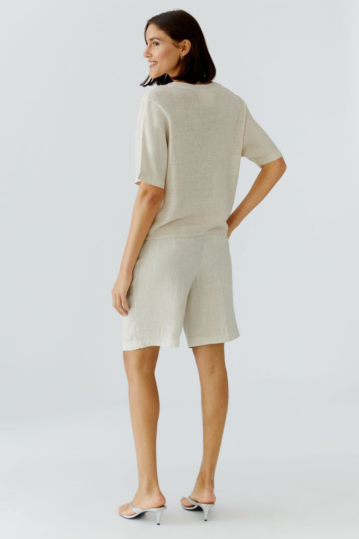 Chandail en maille texturée à manches courtes, vêtement léger beige à coupe fluide, vu de dos sur modèle féminin.