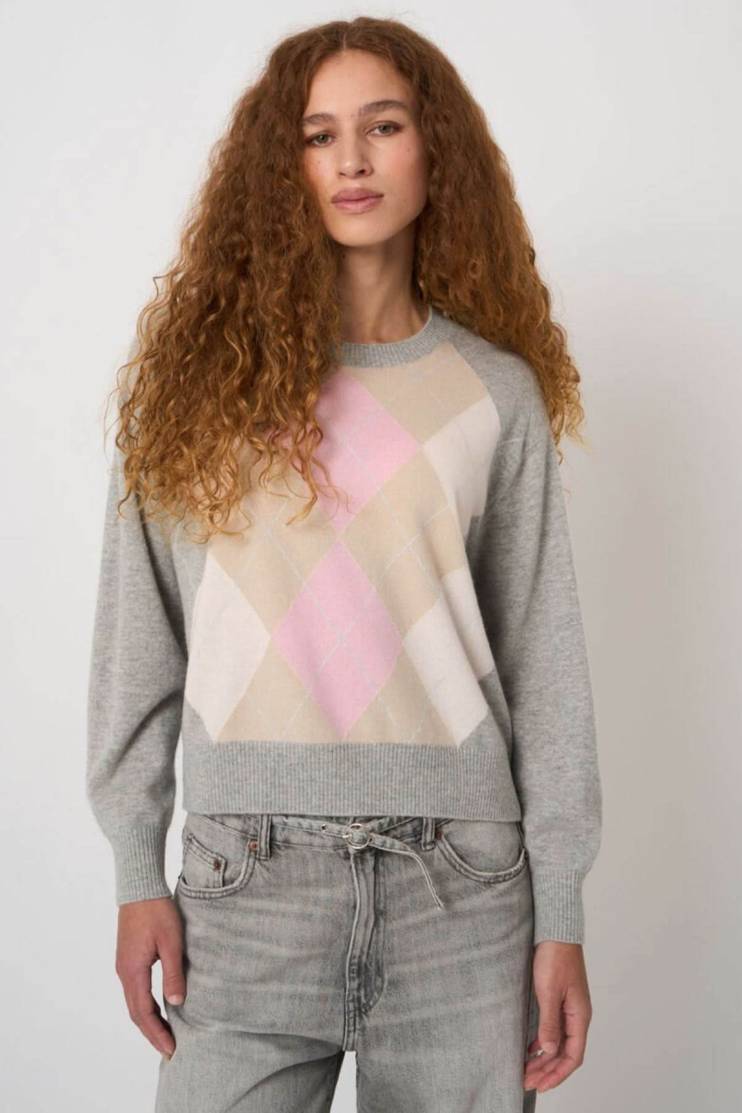 Femme portant un chandail en tricot avec motif géométrique doux, coupe droite, parfait pour usage quotidien.