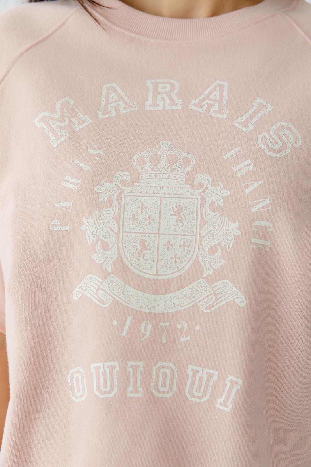 Chandail imprimé graphique rose avec emblème rétro et texte "Marais Paris France 1972 Ouioui"