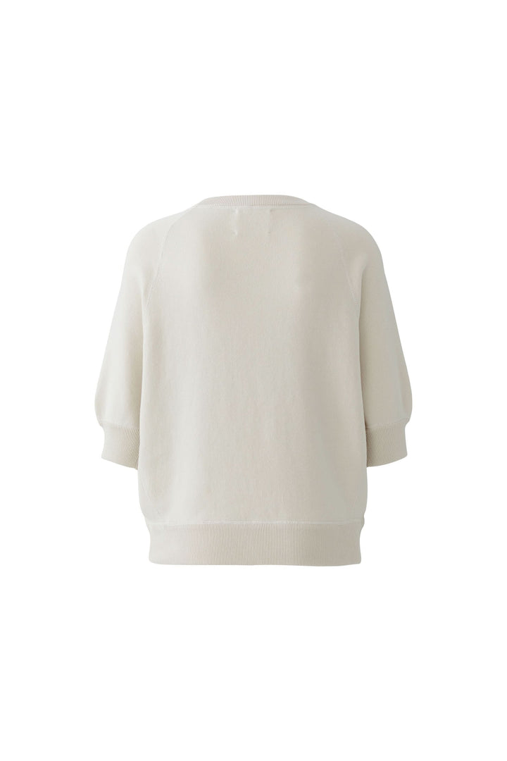 Chandail à imprimé universitaire, couleur crème, manches trois-quarts, coupe décontractée avec encolure ronde et épaules raglan.