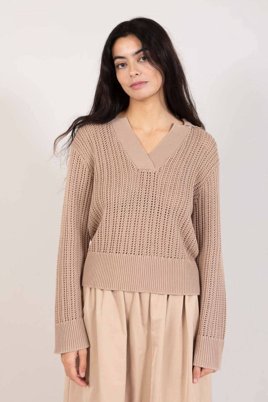 Chandail maille ouverte beige à manches longues et encolure en V, longueur hanches, porté par modèle.