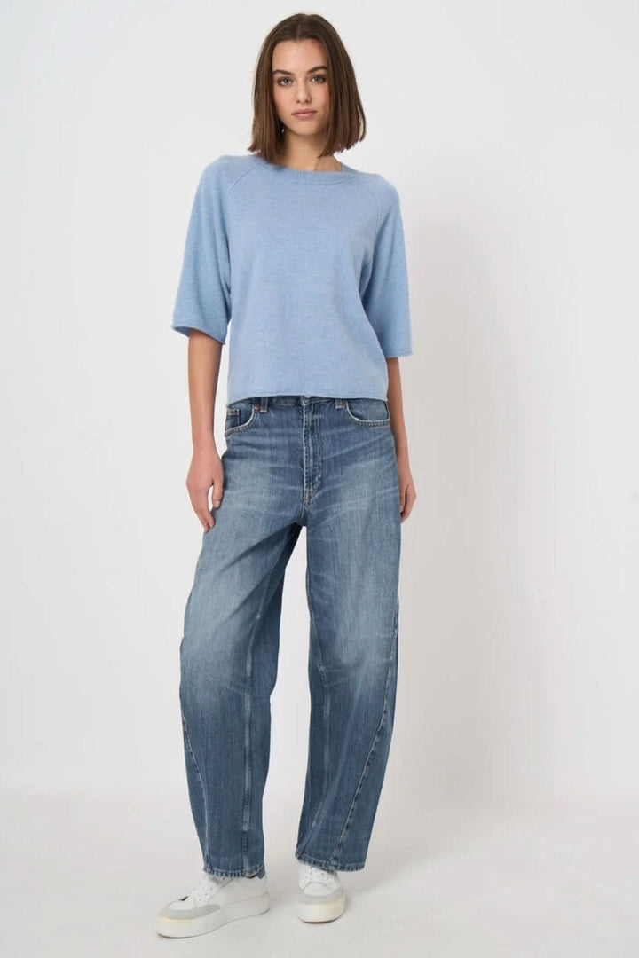 Femme portant Chandail à manches courtes bleu avec coupe droite et encolure ronde, combiné avec un jean décontracté.