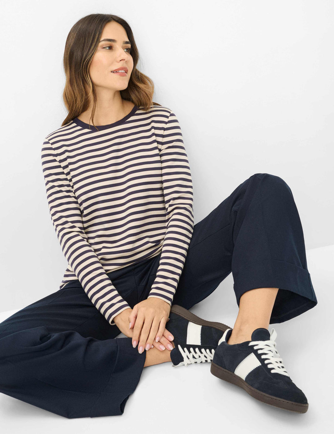 Femme portant le Chandail rayé CARINA L à manches longues et motif intemporel, avec pantalon bleu, assise en pose décontractée.