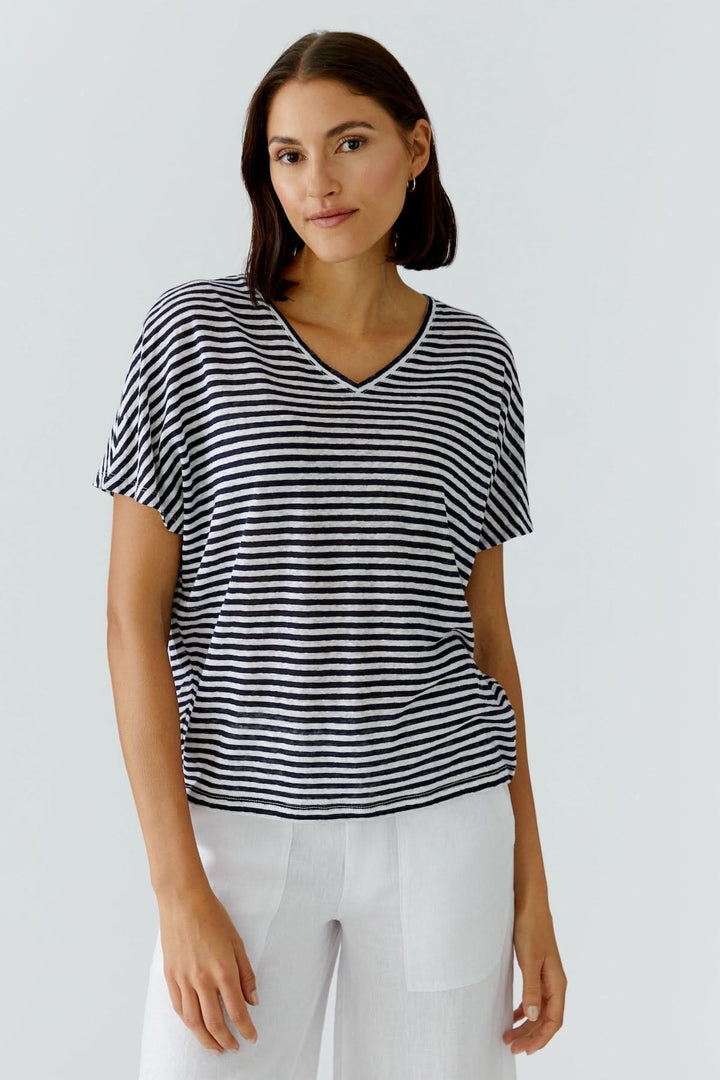 Femme portant un chandail à rayures col en v, coupe décontractée, manches courtes, style moderne et féminin.