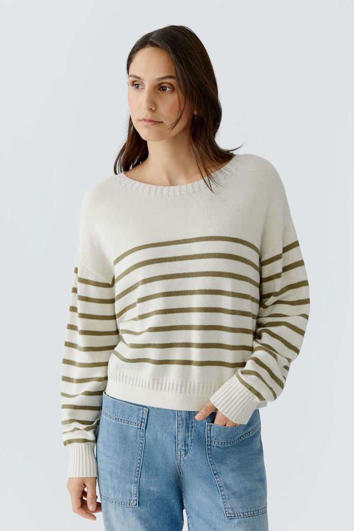 Chandail à rayures en maille douce avec manches longues et encolure ronde, porté par une femme, style décontracté chic.