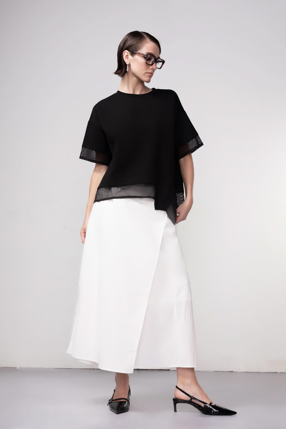 Chandail texturé moderne avec détails en maille ajourée, silhouette ample, idéal pour un look contemporain.