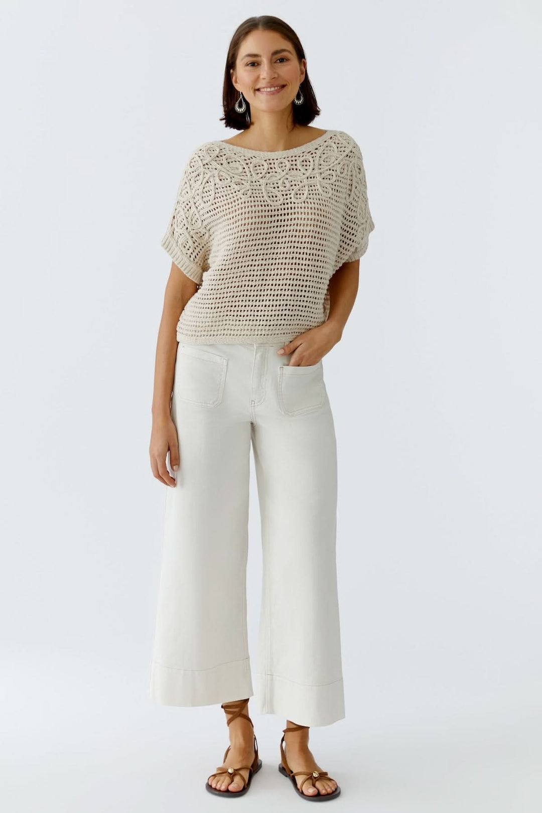 Femme portant un chandail tricot ajouré texturé à manches courtes, élégante et moderne.