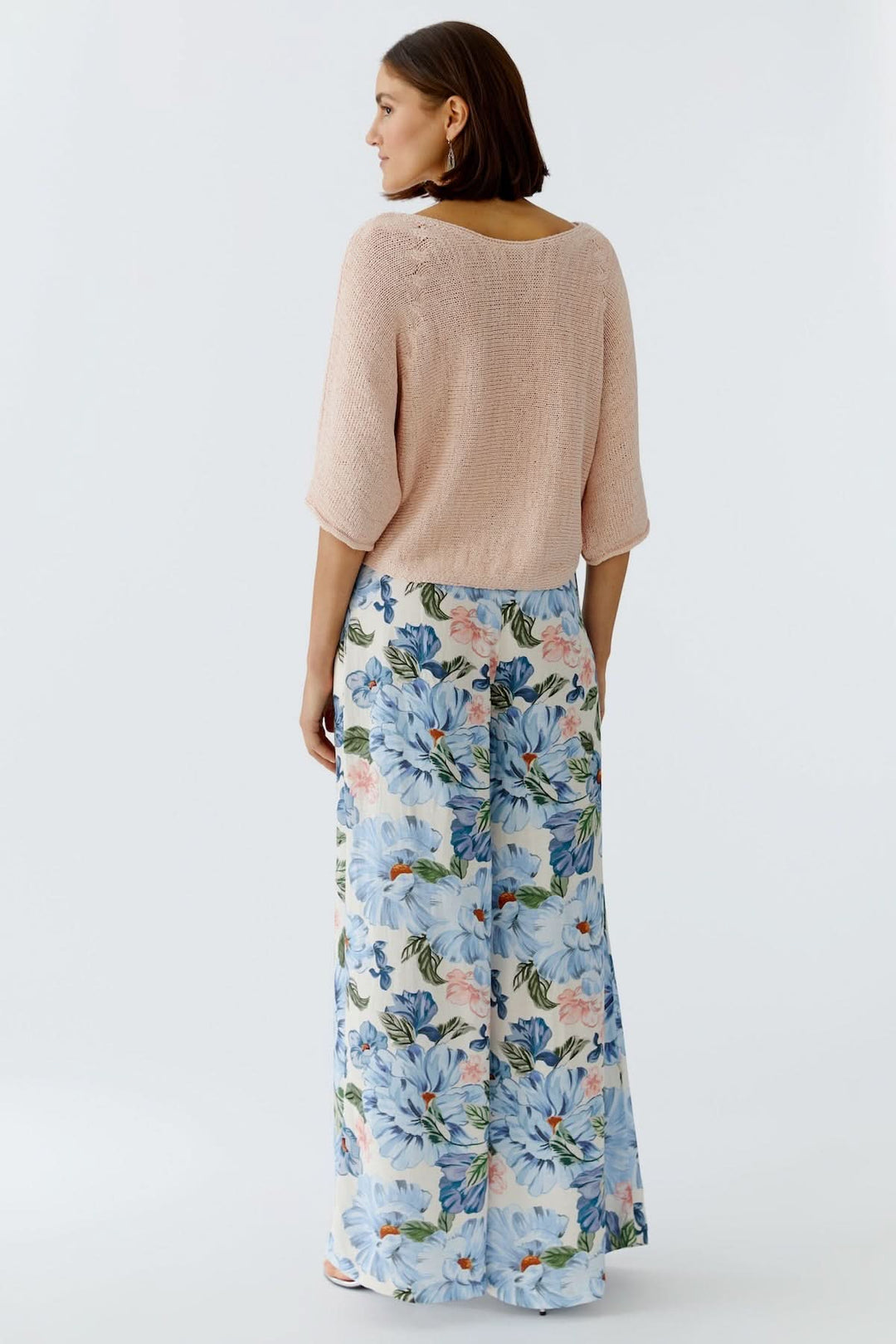 Femme portant un chandail tricot léger rose avec jupe imprimée, vue arrière