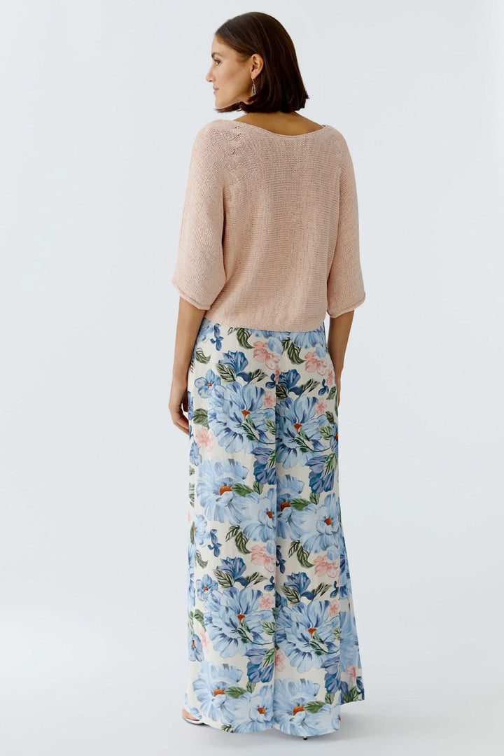 Femme portant un chandail tricot léger rose avec jupe imprimée, vue arrière