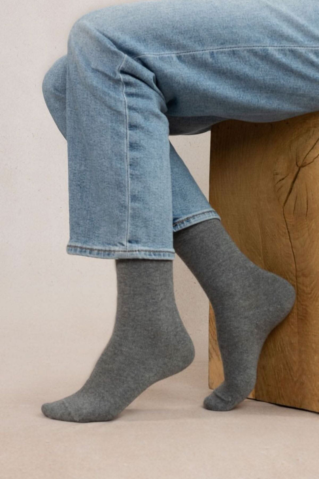 Chaussettes cachemire unies grises portées avec un jeans, ajoutant confort et chaleur pour l&