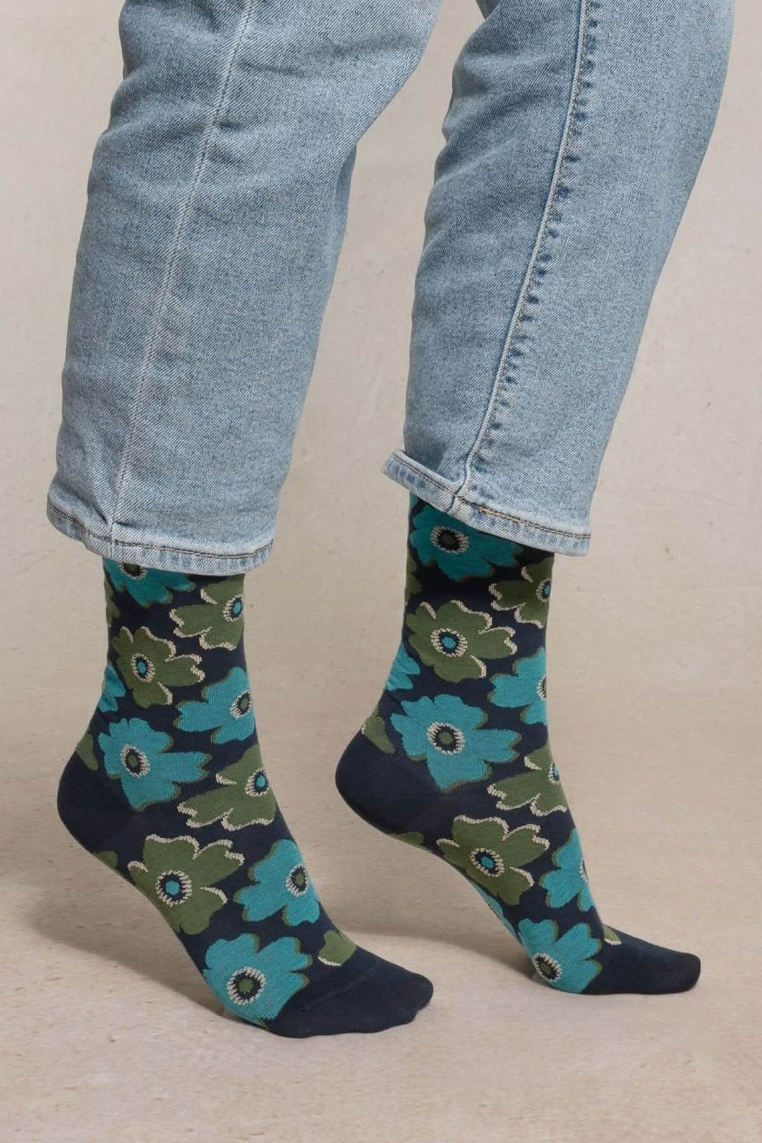 Chaussettes à motif floral mi-mollet en coton, portées avec un jean légèrement retroussé, imprimé vibrant et bord-côte souple.