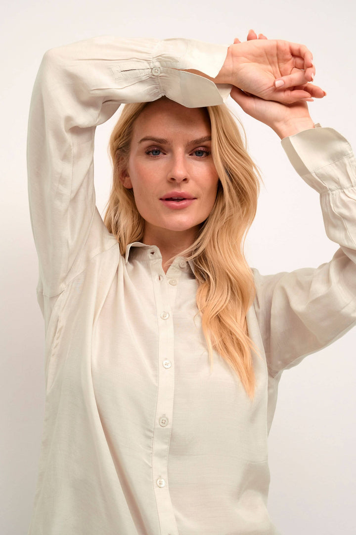 Femme portant une chemise Arina à manches longues, affichant un style décontracté et contemporain.