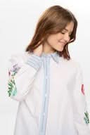 Chemise brodée à manches longues avec broderies florales et poignets rayés, modèle élégant pour un style raffiné.
