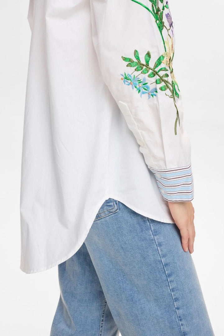 Chemise brodée à manches longues avec broderies florales et poignets rayés pour un style raffiné et artistique.