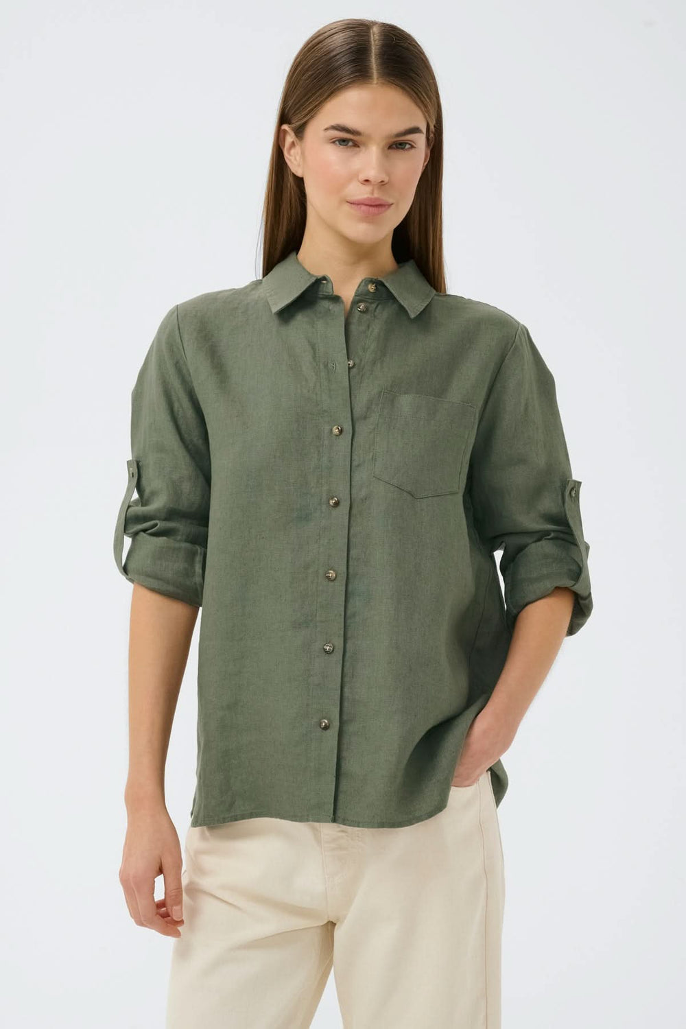 Chemise en lin Dilana verte avec col classique, manches longues retroussables et coupe fluide, portée par une femme