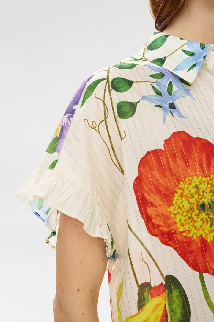 Chemise fluide imprimée à manches volantées avec détails floraux colorés et finitions volantées sur les manches courtes, vue de côté.