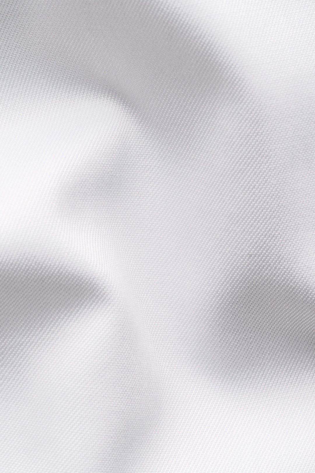Tissu blanc élégant et texturé, idéal pour une chemise habillée raffinée et confortable.