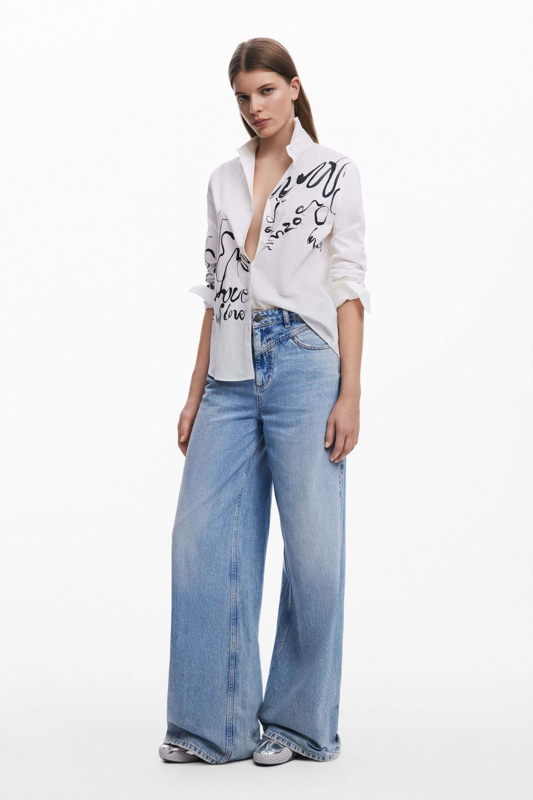 Chemise imprimée de lettres en encre portée avec un jean large, look moderne et élégant.