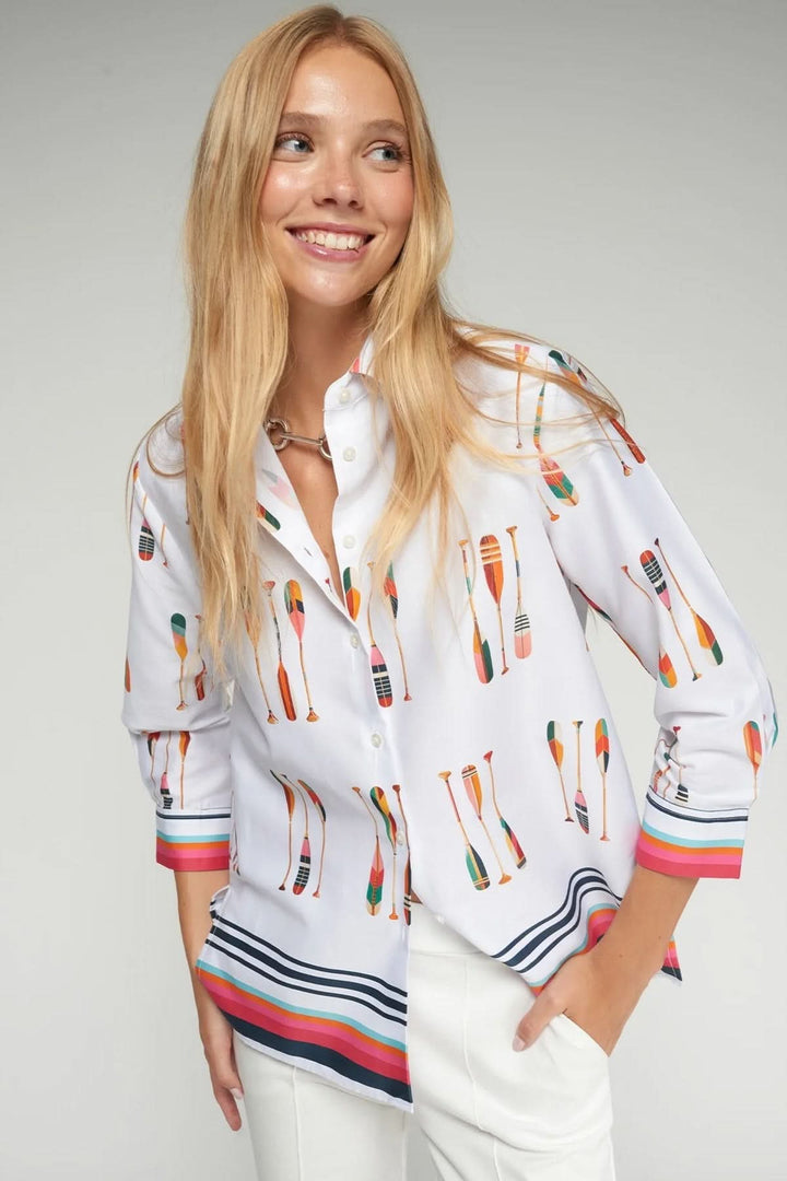 Femme portant une chemise imprimé pagaies avec col classique et fermeture boutonnée, détails contrastants sur poignets et ourlet.