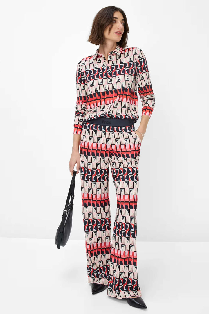Chemise imprimée Celina avec motif géométrique, associée à un pantalon fluide pour un look chic.