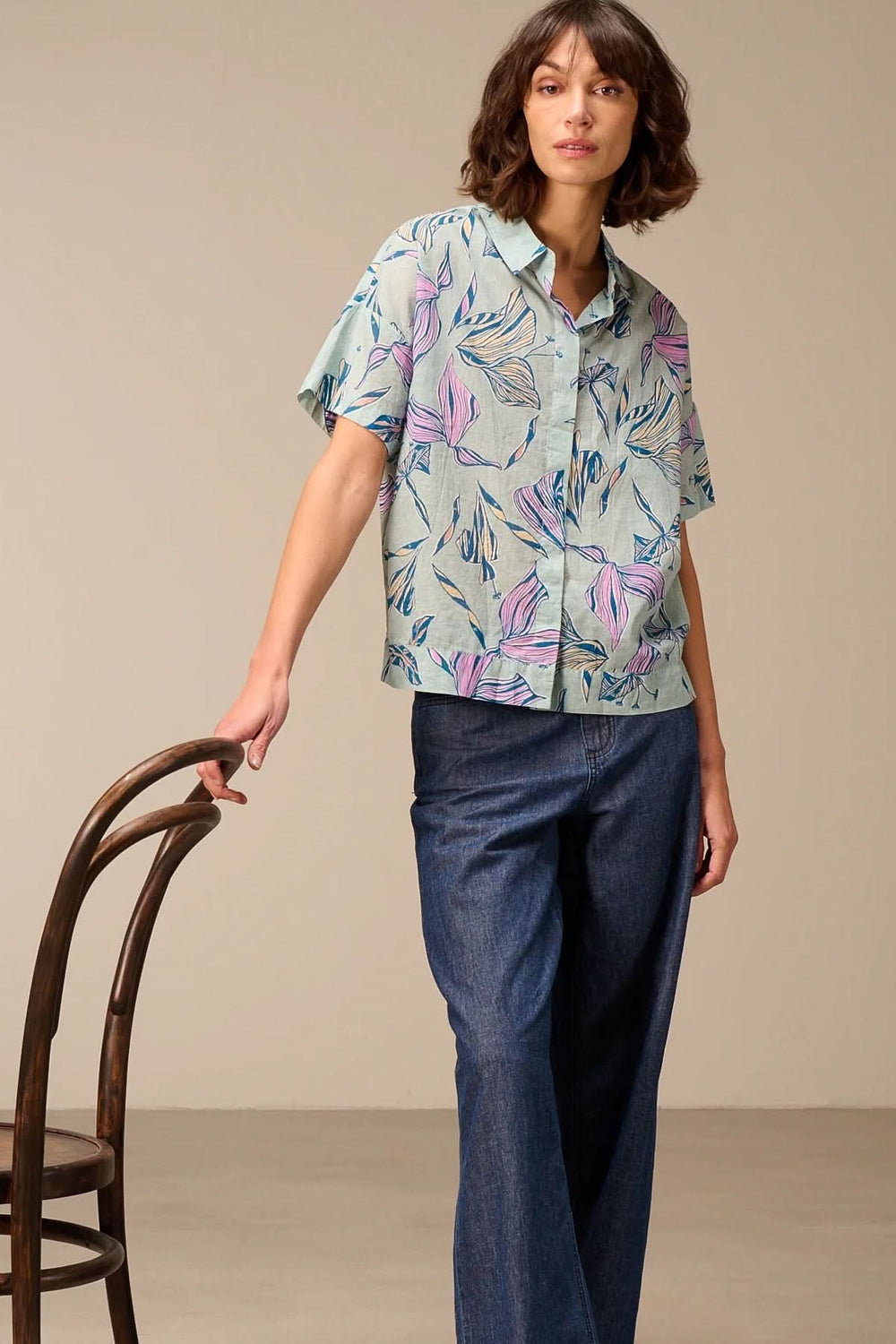 Chemise légère à manches courtes avec imprimé portée par un modèle, parfaite pour un look estival et élégant.