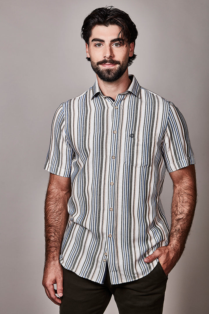 Homme portant une chemise à manches courtes à motif rayé, élégante et moderne, idéale pour un style soigné, avec col classique.