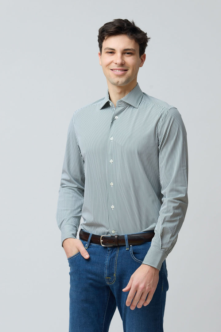 Homme portant une chemise à rayures vertes fines avec jeans pour un style moderne et élégant.