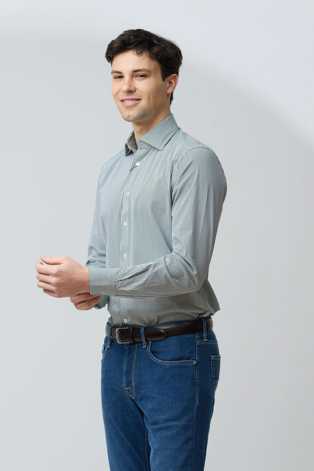 Homme portant une chemise à rayures vertes fines, coupe ajustée, pour un style moderne.