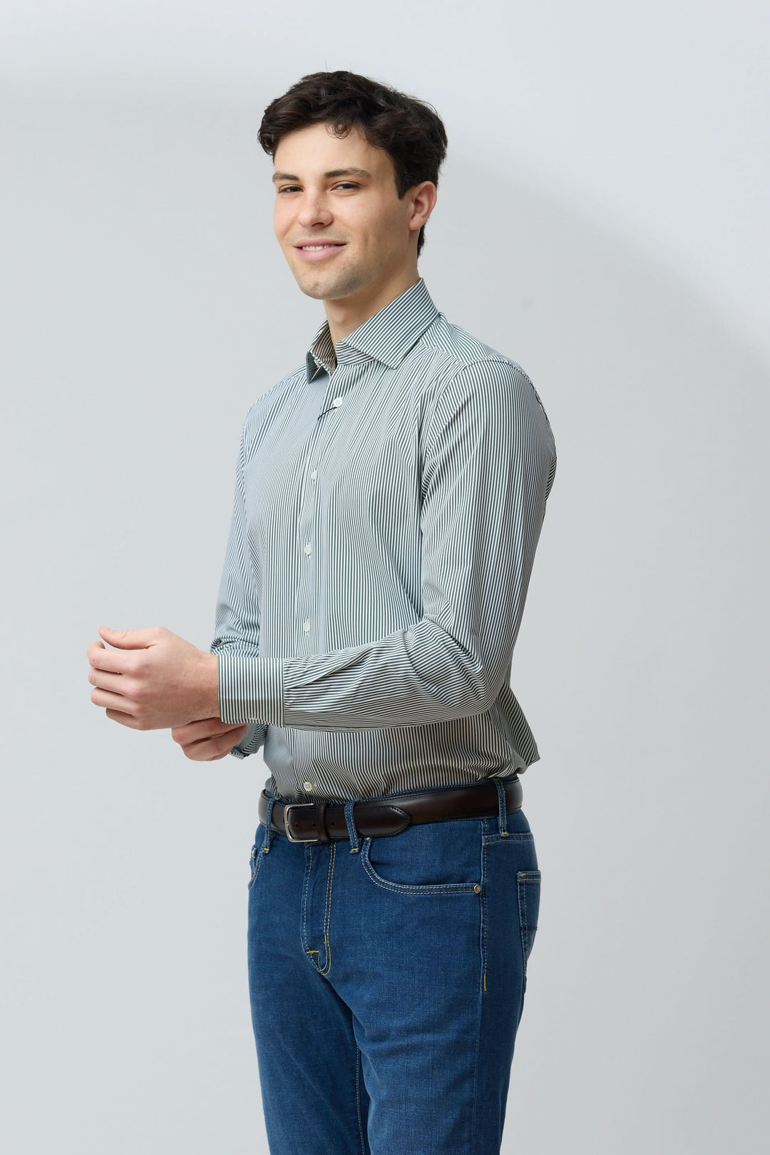 Homme portant une chemise à rayures vertes fines, coupe ajustée, pour un style moderne.