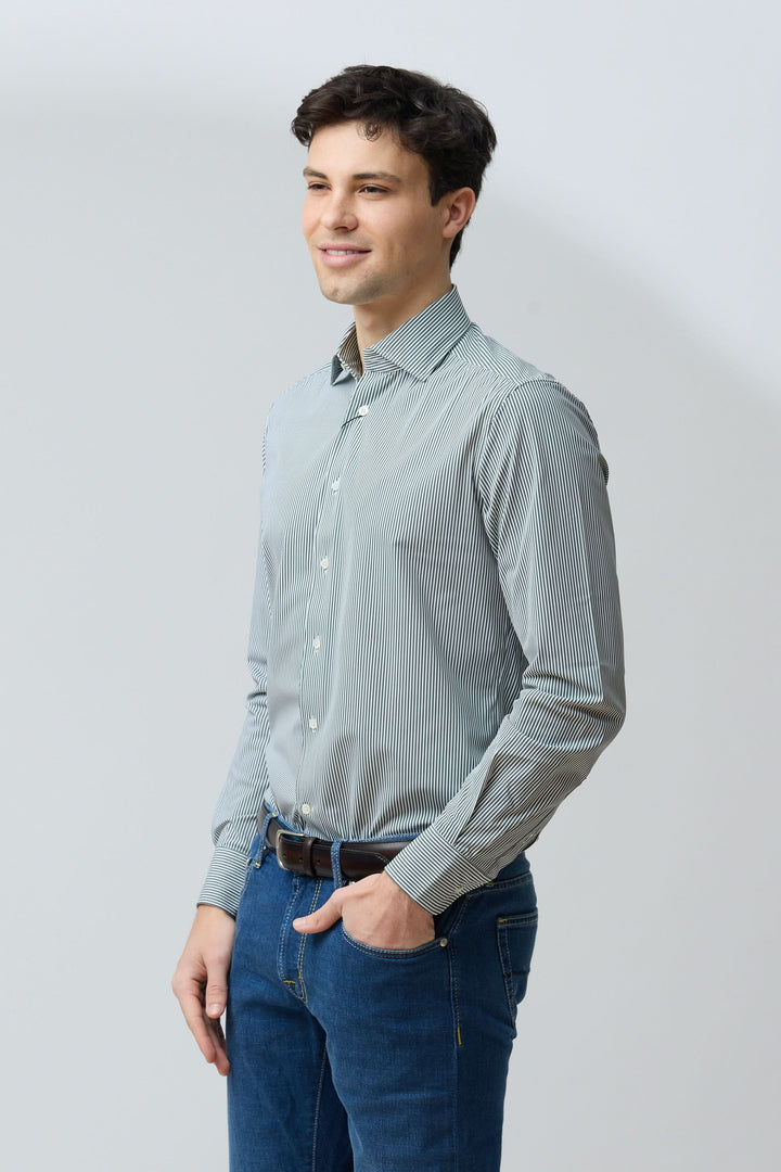 Homme portant une chemise à rayures vertes fines et jeans, coupe ajustée, idéale pour un look professionnel ou décontracté.